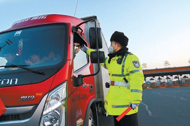 正月初五，京承高速主收费站上，获评“北京榜样”的朝阳交通支队民警敖翔开始了节日后期返程高峰的疏导工作。本报记者甘南摄