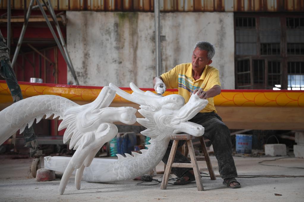 6月14日,工人在汨罗市九子龙屈原龙舟有限公司制作龙舟.