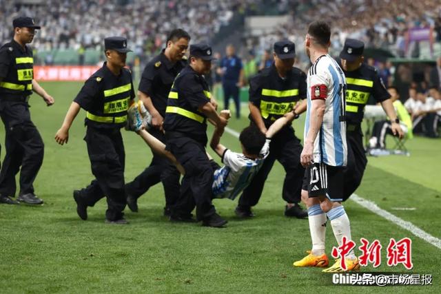 在比赛中冲入赛场内的球迷被抬离赛场。中新社记者 富田 摄