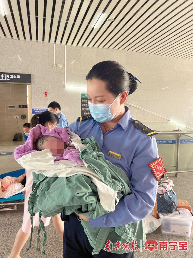 客运员邓锦波在悉心照顾出生小孩,等待转移至急救车上 通讯员 沙柱婵