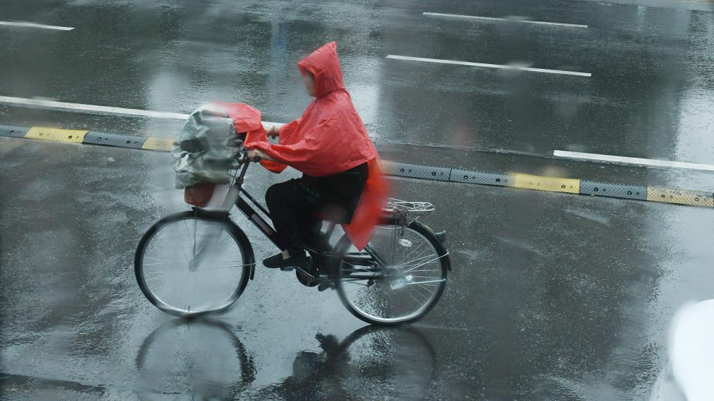 安徽省阜阳市，市民在雨中出行。视觉中国 图