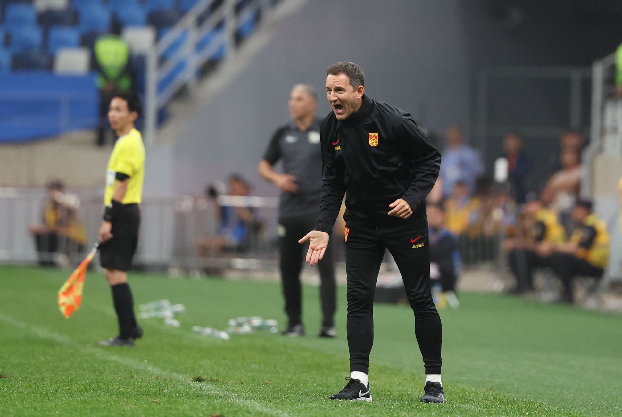 6月20日,中国队主教练扬科维奇(右)在比赛场边指挥.新华社记者曹灿摄