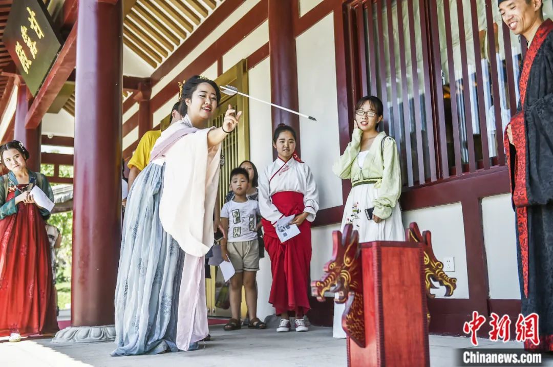 河南省洛阳市传统文化研究会会员身着汉服,与市民游客互动"投壶"等