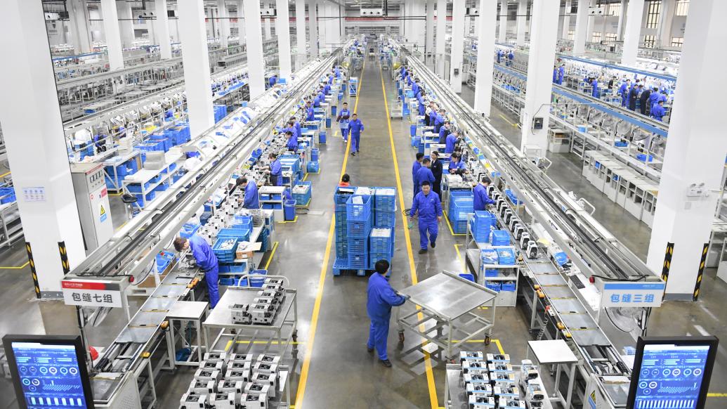 工作人员在装配车间装配缝纫机