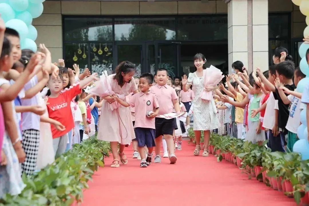 2022年7月1日，山东省东营市东营区文馨幼儿园的小朋友们在毕业典礼上走出“毕业大门”。宋星刚 摄