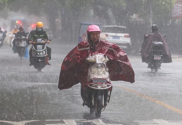 2023年6月20日,南昌市气象台发出暴雨橙色预警,市民在大雨中骑行.