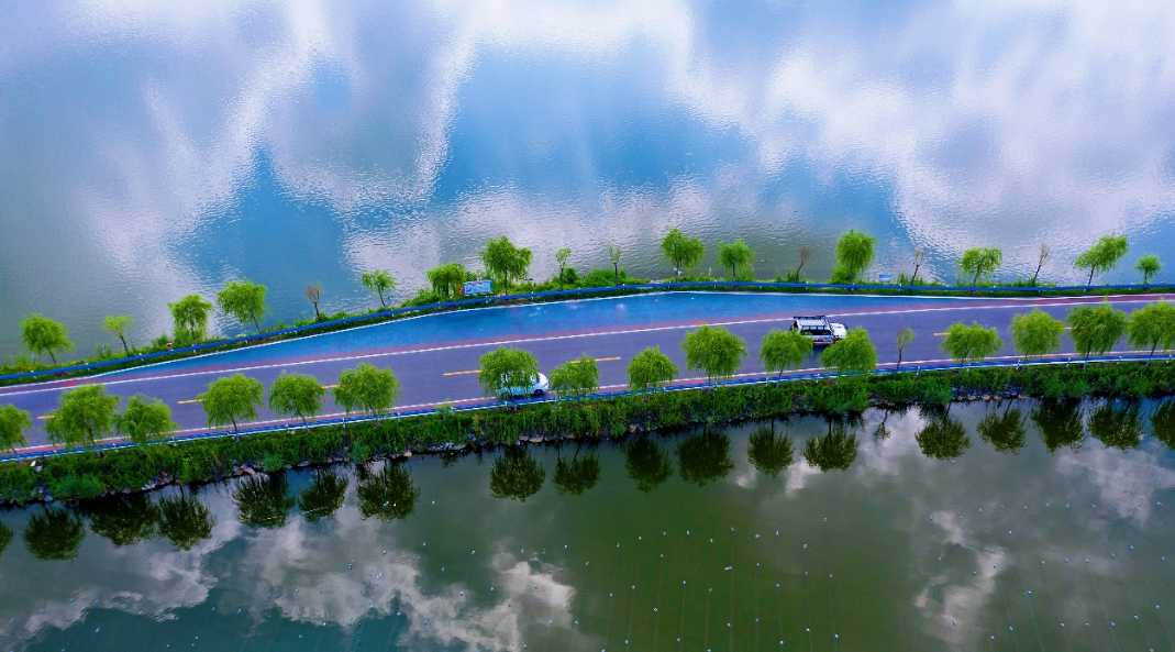 6月26日,在安徽省淮北市杜集区航拍的一条乡村公路,宛若穿梭在白云中.