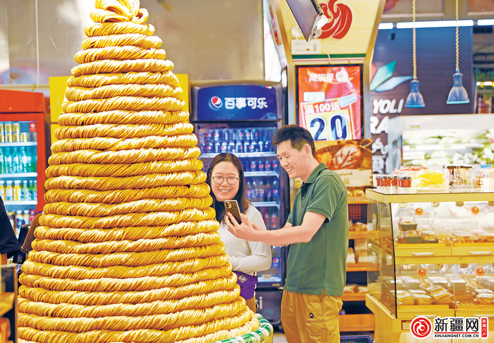 6月26日,在天山区阿尔曼超市(领馆巷店),商家摆出90公斤的大型馓子塔