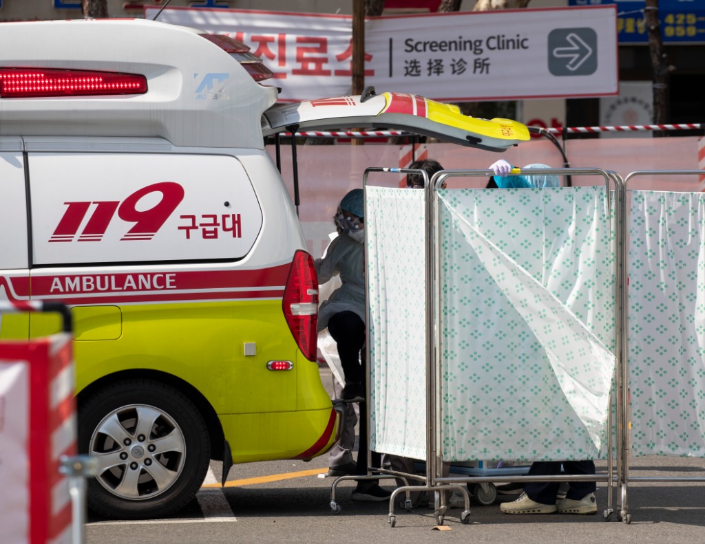 2020年3月4日,在韩国大邱庆北大学医院,医护人员从救护车上下来.