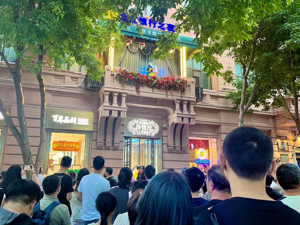 游客在中央大街欣赏阳台音乐会.新华社记者 杨思琪 摄