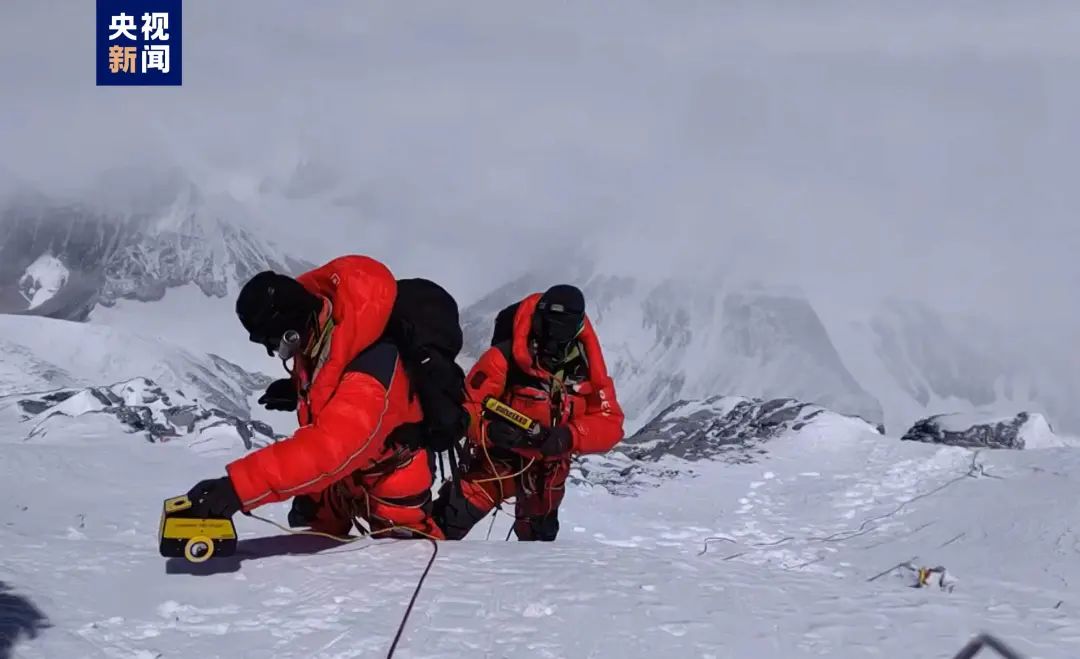 2022年5月4日，“巅峰使命”珠峰科考登顶科考队员在珠峰峰顶展开测厚工作。图片来源：央视新闻