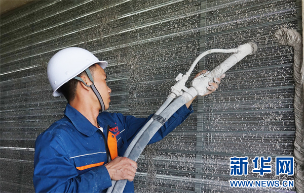 工人用磷石膏喷筑复合墙体.(受访企业供图)