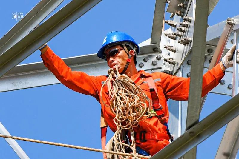 烈日下电网"蜘蛛侠"正在高空作业||高温下,一位电网工人正在补水