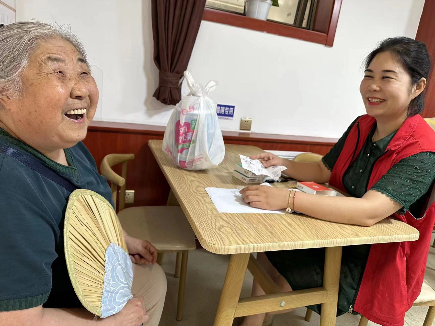 养老驿站服务人员为老人讲解"易健呼"使用方法