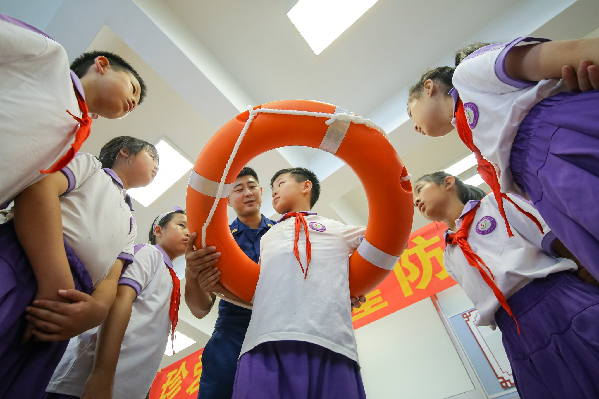 消防员指导孩子正确使用救生圈