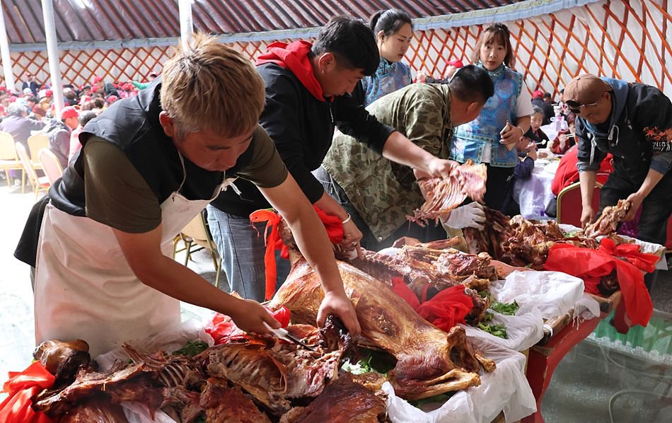 内蒙古呼伦贝尔安达景区,游客在蒙古包内品尝烤全羊.视觉中国 图