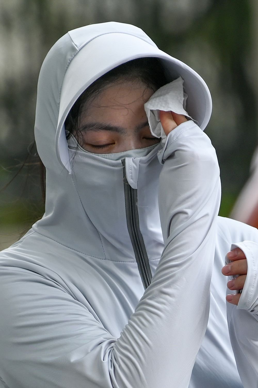 2023年7月14日,上海铜仁路,女子用纸巾擦汗.