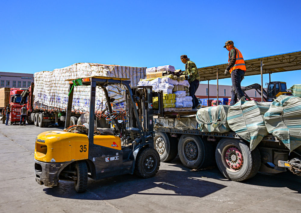 2023年6月11日,工人在二连浩特口岸旁的进出口物流园区中装载准备出口
