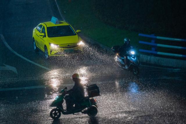 2023年7月13日晚,重庆中心城区出现暴雨天气,市民在雨中穿行.