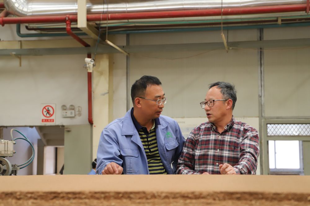 杜官本教授(右)在和企业负责人交流.西南林业大学供图