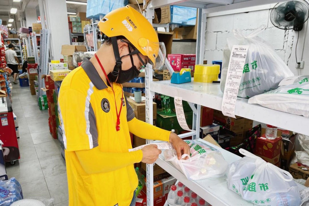 美团骑手在仓店货架上核对订单取货
