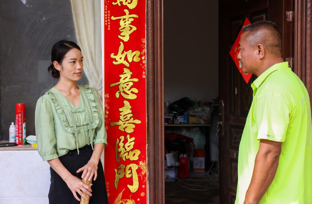 7月20日,在云南省普洱市江城县,刁发兴(右)向村民通报象群活动信息.