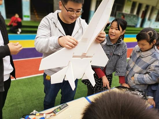 志愿者与孩子们一起制作航模飞机.受访者供图