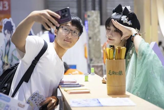 张欣羽为粉丝在照片上签名。