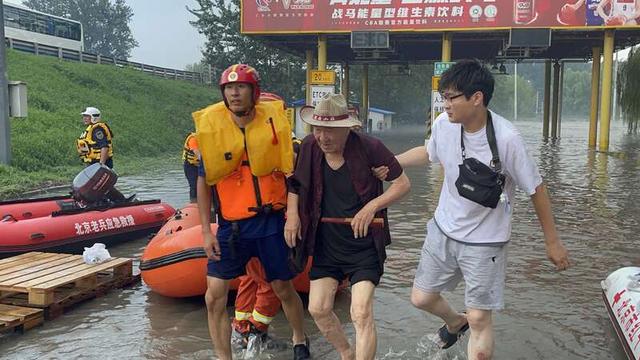 在救援人员的搀扶下，受灾老人撤离转运现场。中青报·中青网记者 韩飏/摄