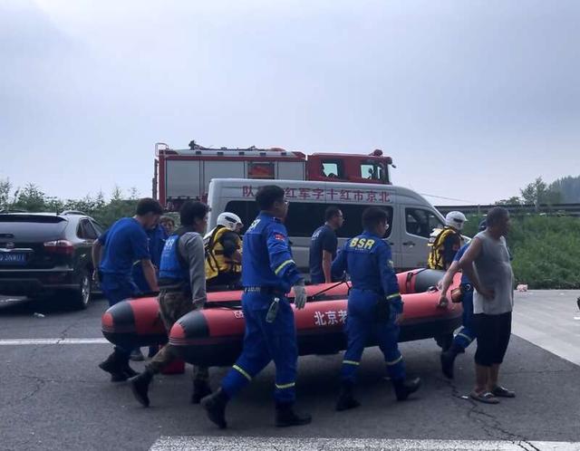救援人员抬着崭新的救援艇前往岸边转运。中青报·中青网记者 韩飏/摄
