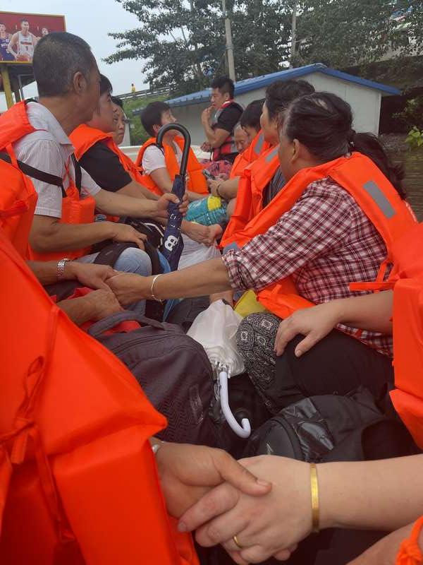 转运船上，大家不约而同地拉着手，坐在一起。中青报·中青网记者 韩飏/摄