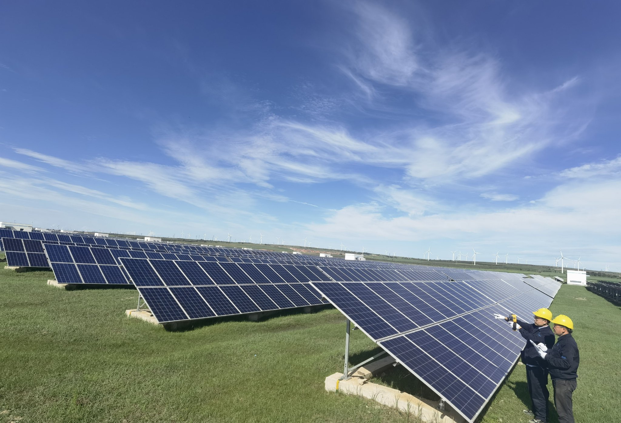 中核集团尚义光伏电站运维人员正在巡视检查光伏组件.