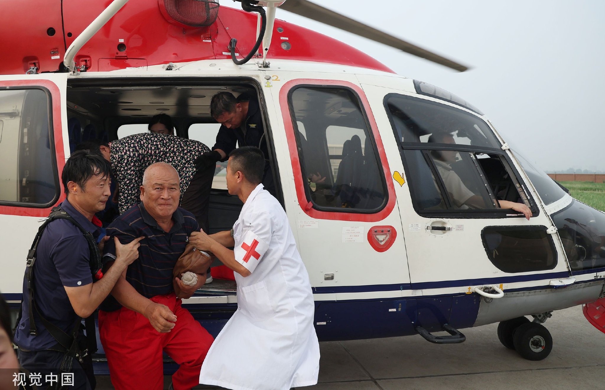 2023年8月3日,河北涿州,直升机将受困村民接回安全区域并接受医生治疗