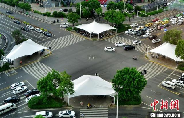 图为福州市华林路五四路口的渠化岛上建起了4个超大遮阳棚,为等候红灯