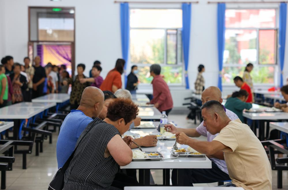8月11日，村民在舒兰三中安置点食堂里吃饭。新华社记者颜麟蕴 摄