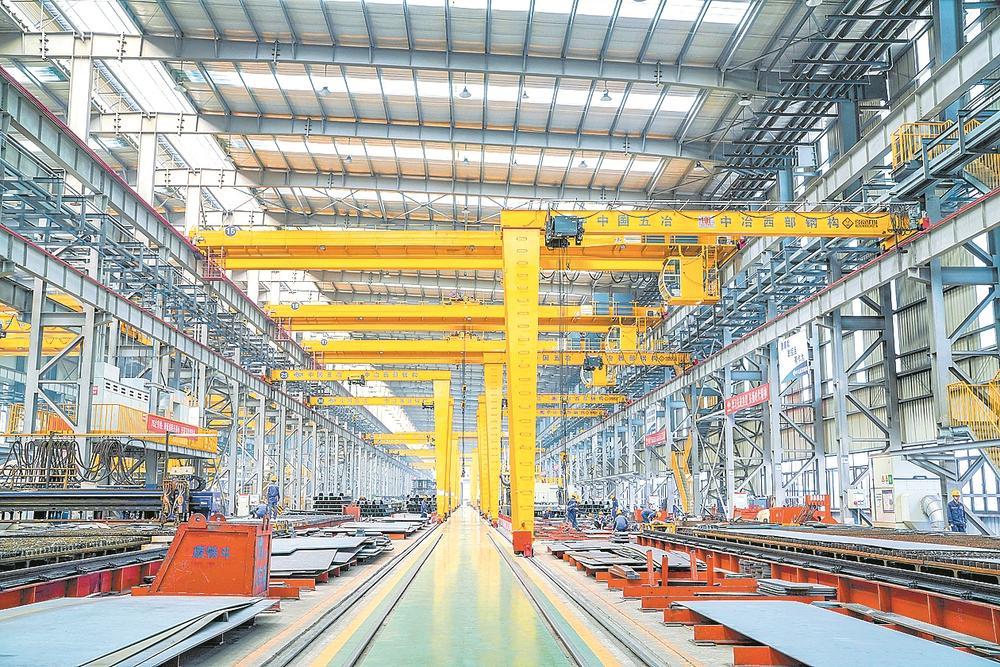 车间里,技术人员忙碌有序地进行钢结构生产工作