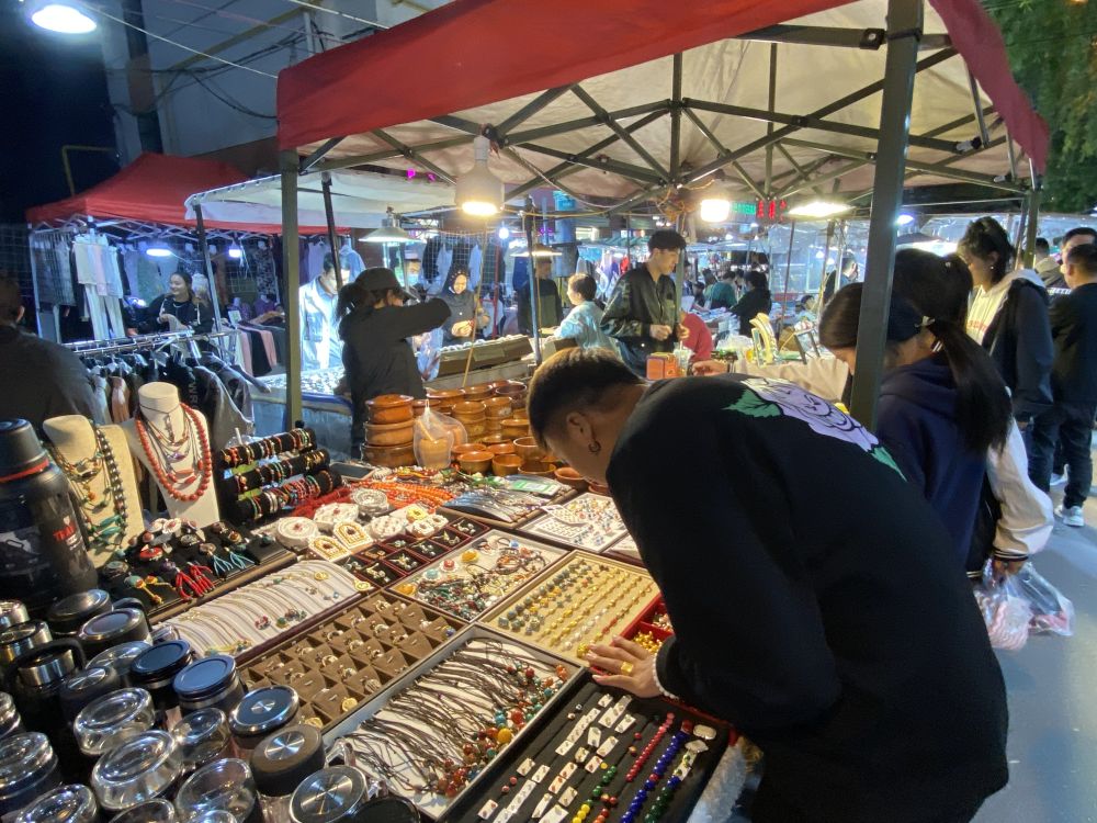 6月20日,西宁市城中区大新街夜市一家摊铺吸引游客驻足.