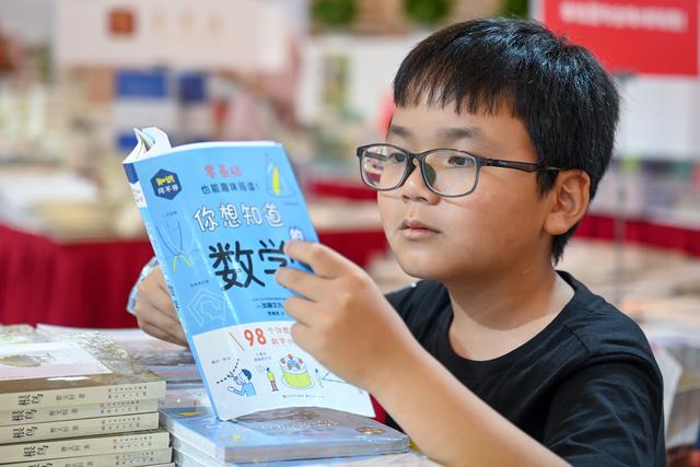 2023年8月16日,上海展览中心,一位小男孩在看书.