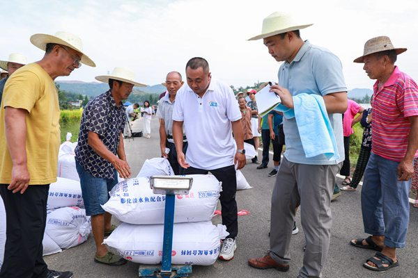 专家和邓中对稻谷进行称重记录.熊伟 摄