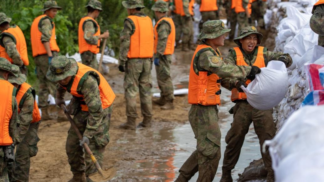 8月8日,在哈尔滨市双城区万隆乡增产村抗洪现场,官兵在运送筑坝沙袋.