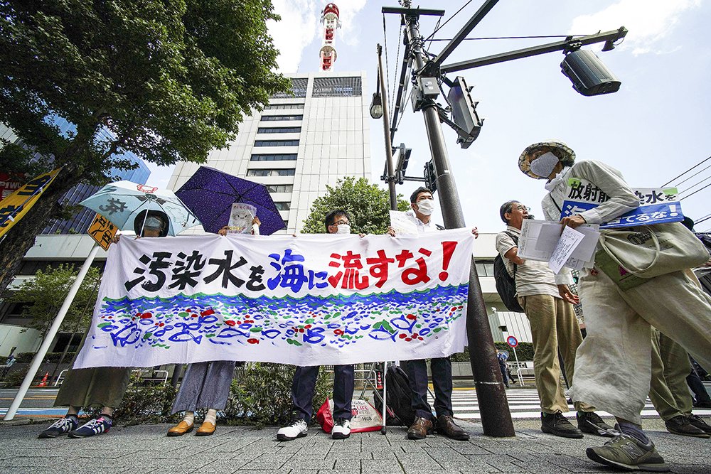 抗议日本政府计划将福岛第一核电站处理后的废水排放到海洋中,标语上