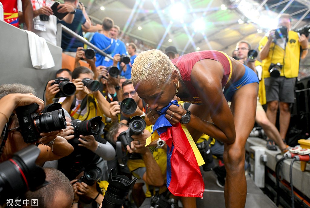 罗哈斯亲吻委内瑞拉国旗.