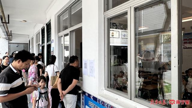 在南宁市新兴民族学校,新生家长在教室门口可查看信息 本报记者 许炀