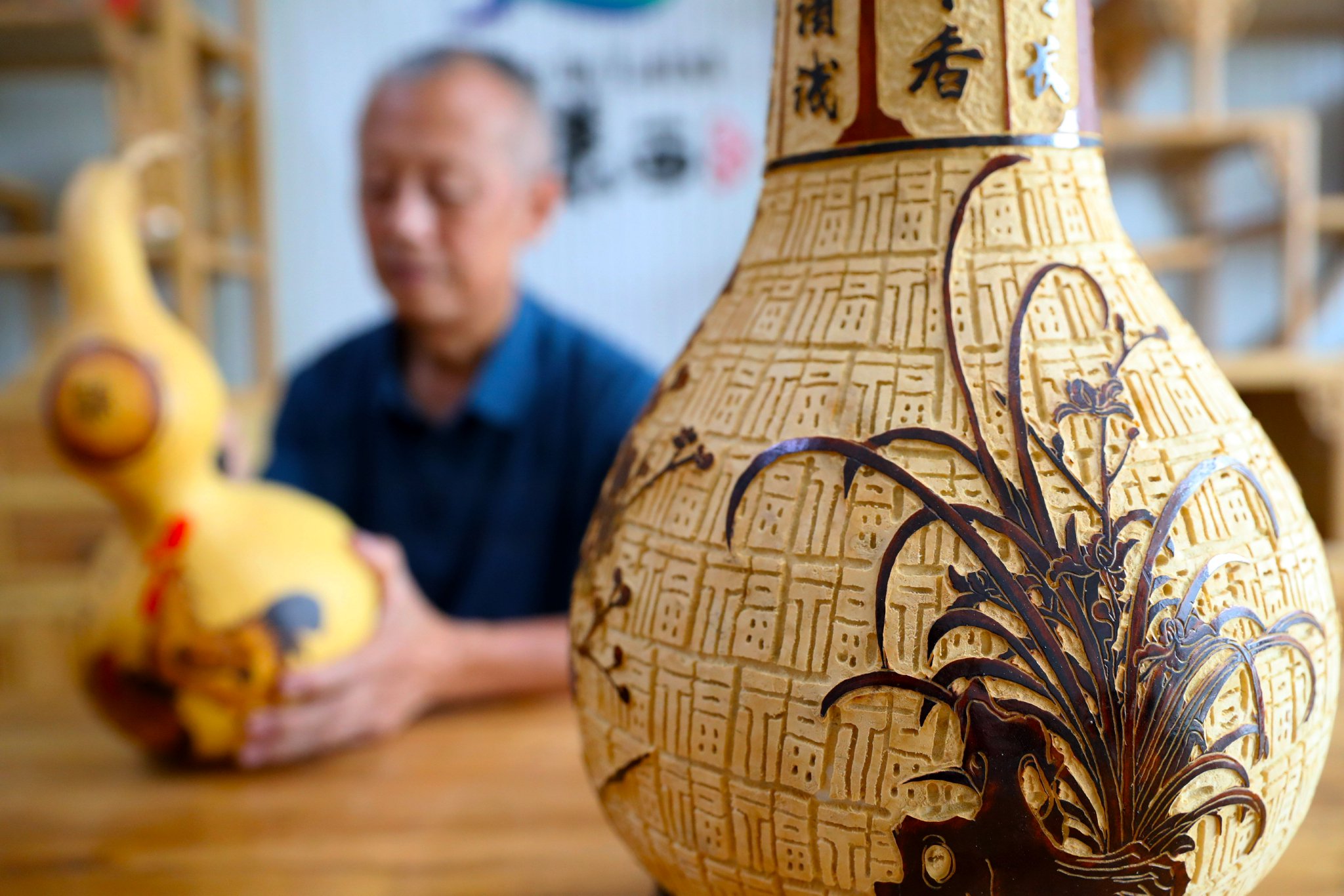 8月27日,周强一在葫芦上雕刻的兰花.张进刚 摄