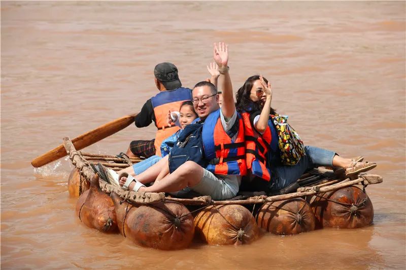 游客在兰州乘坐羊皮筏子畅游黄河