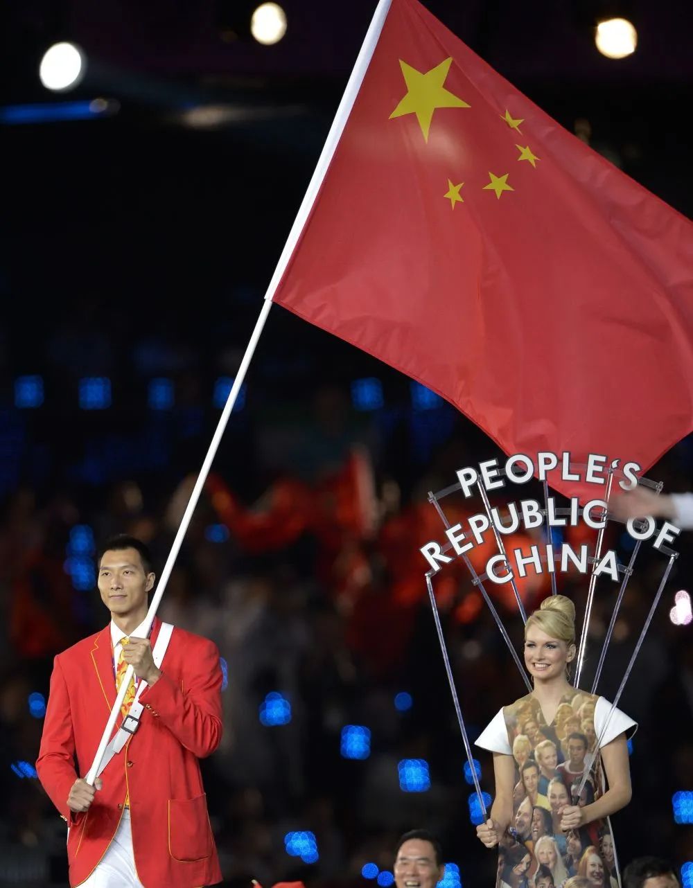 这是中国代表团旗手易建联(左)手执国旗入场.