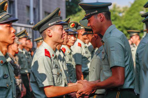图为退役士兵与官兵握手嘱托.李章禄 摄
