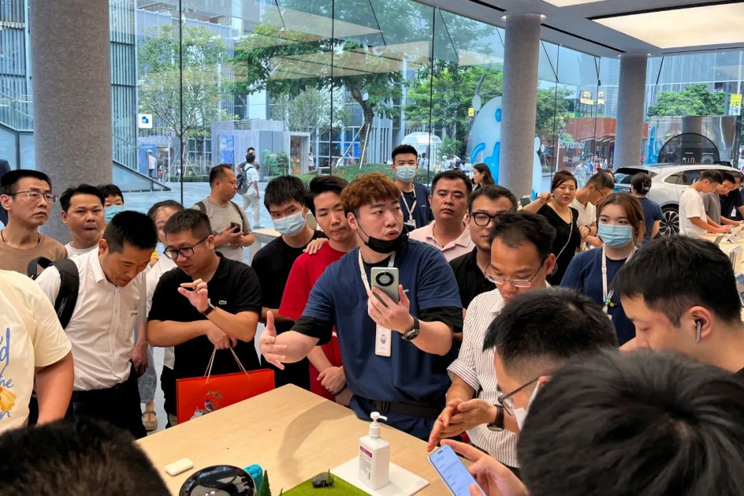 8月30日,在深圳市的华为旗舰店里,一名工作人员向顾客介绍mate060