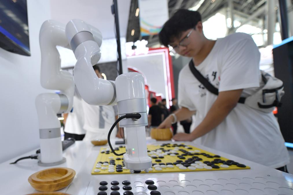 9月6日,参观者在本届数博会上体验与5g智能机器人下围棋.