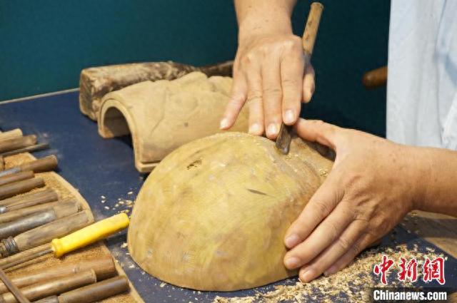 图为桂北傩面具制作技艺代表性传承人唐江峰在雕刻傩面具.欧惠兰 摄